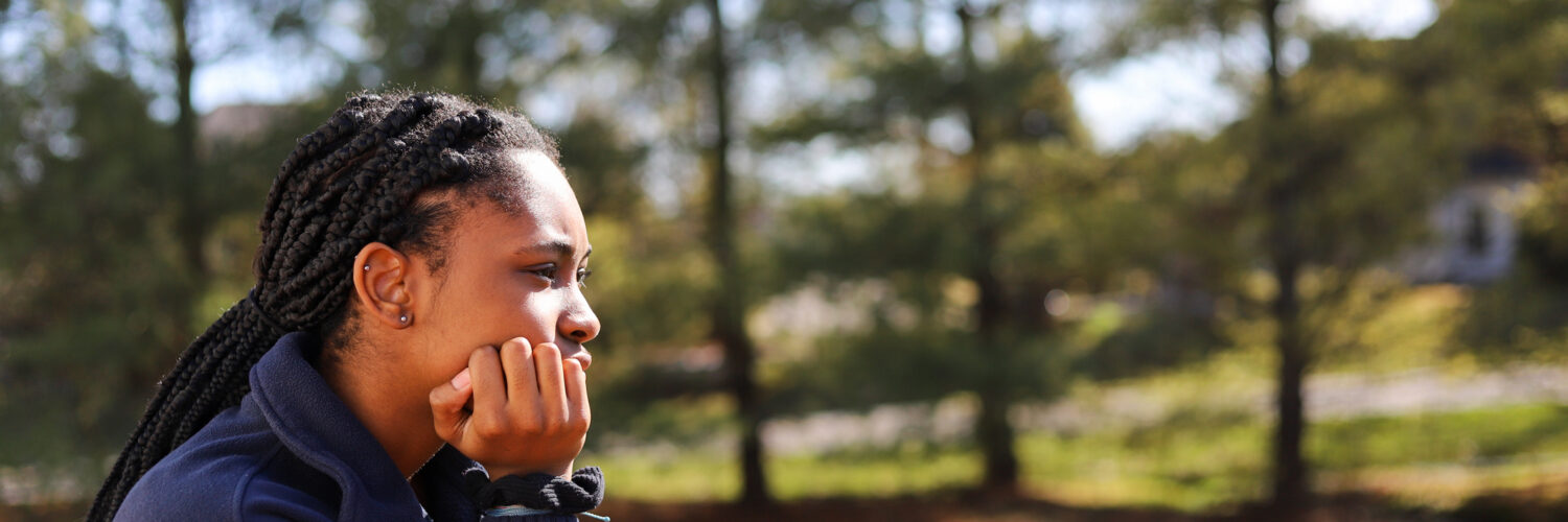 portrait of an African-American teenaged girl looking away in deep thought