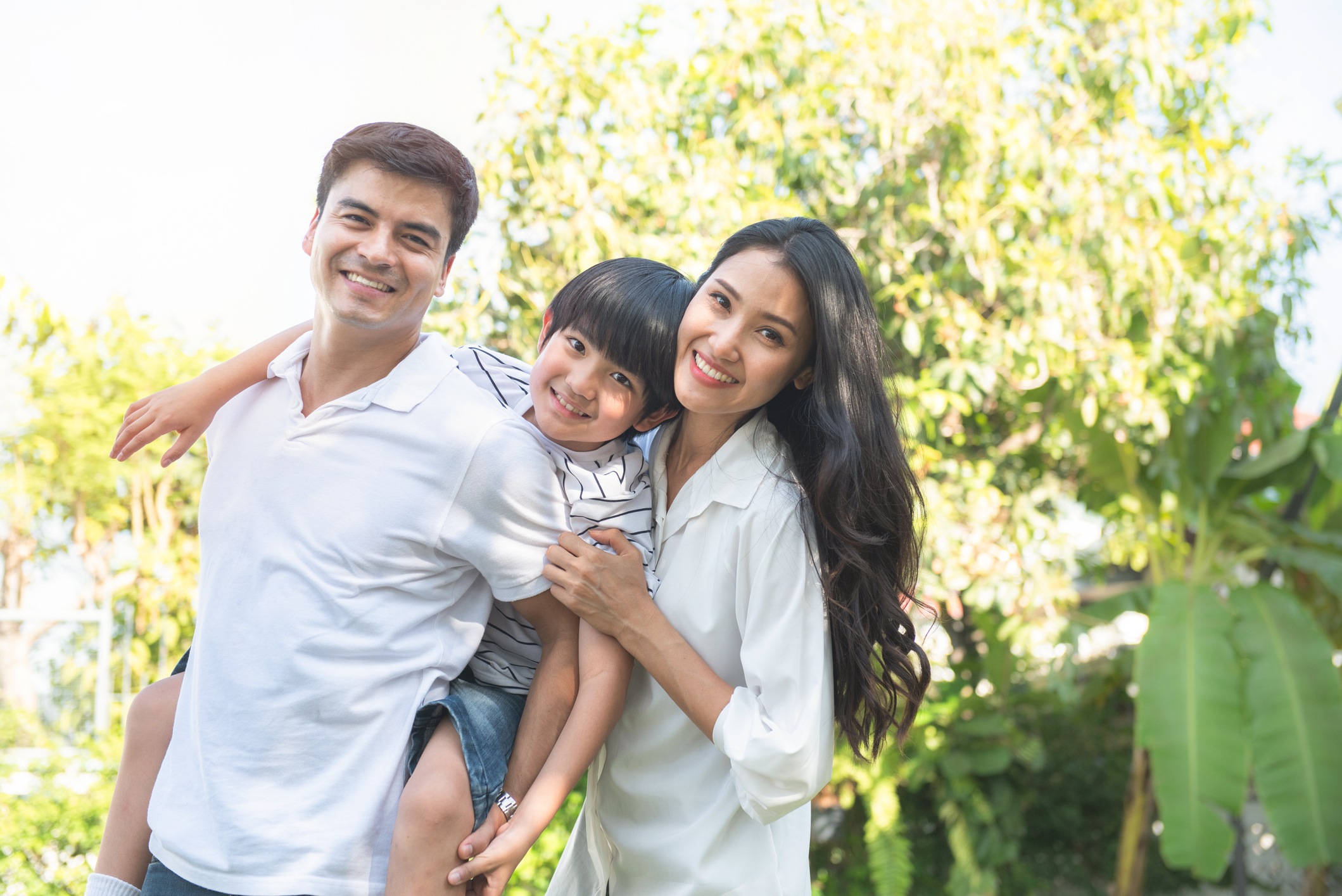 Happy multiracial caucasian asian family man piggyback little boy and ...