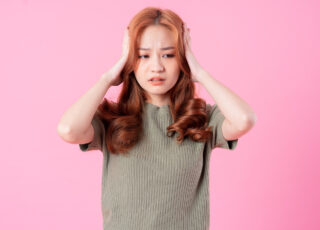Young Asian woman posing on pink background